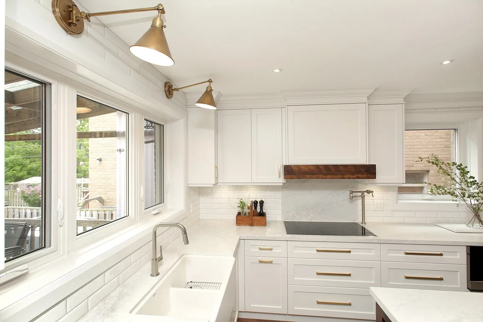 Modern kitchen with white cabinets, brass hardware, and subway tile backsplash.