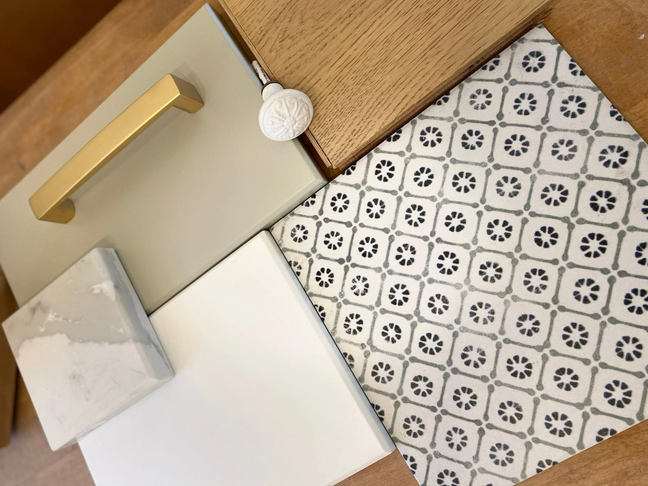 Close-up of a wooden desk and cabinets with a patterned tile floor.
