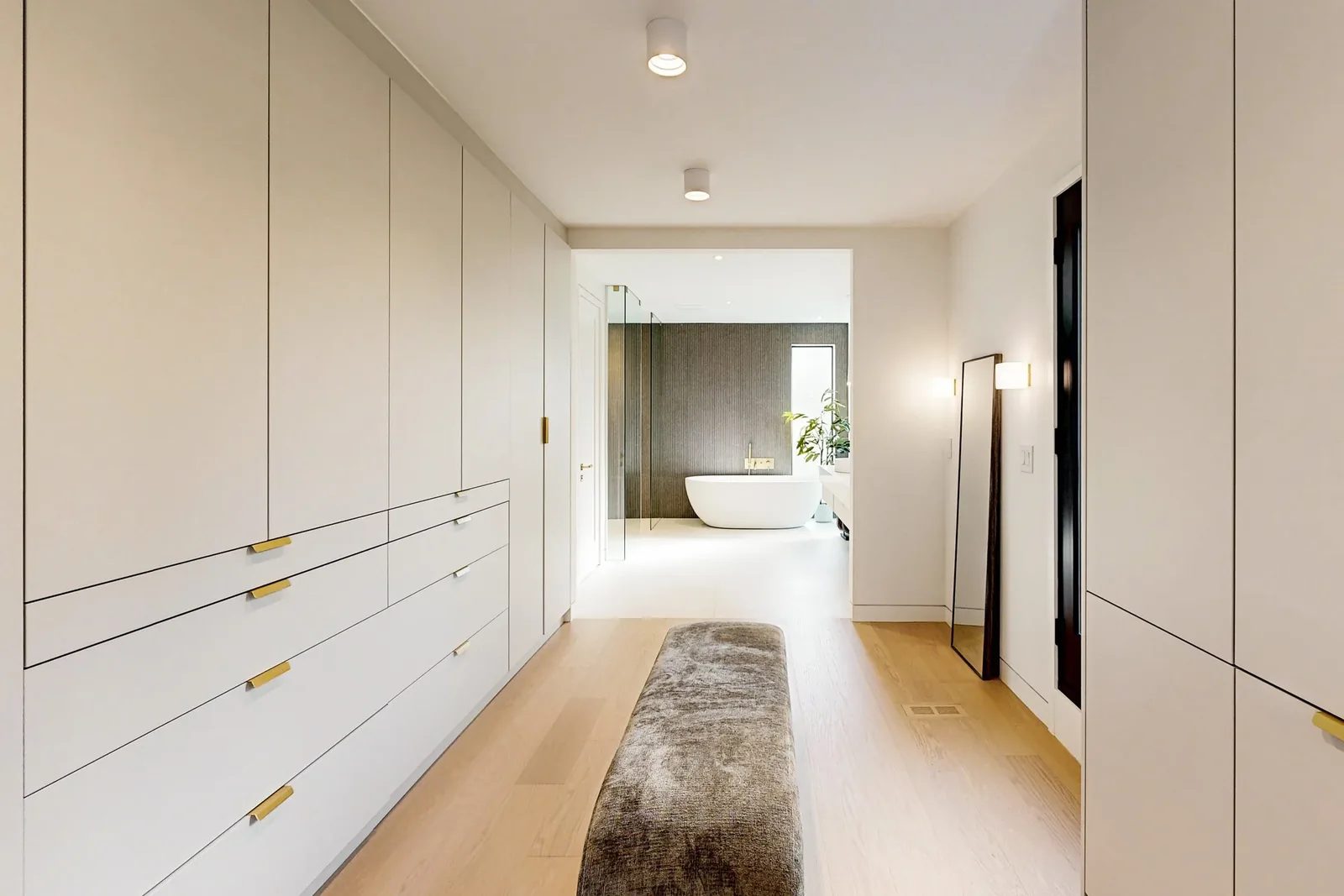 Dressing corridor lined with built-in wardrobes linking the principal bedroom to the spa ensuite.