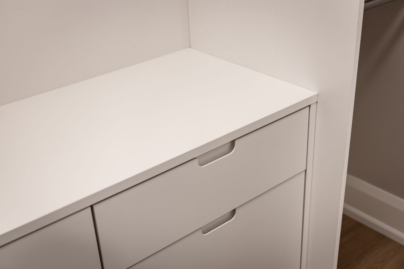 Cabinet drawer bank with integrated finger pulls under a mitred quartz counter.