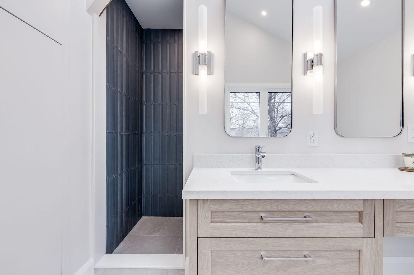 Vanity run with the dark fluted tile wet area beyond, pairing the tile work and the cabinetry.