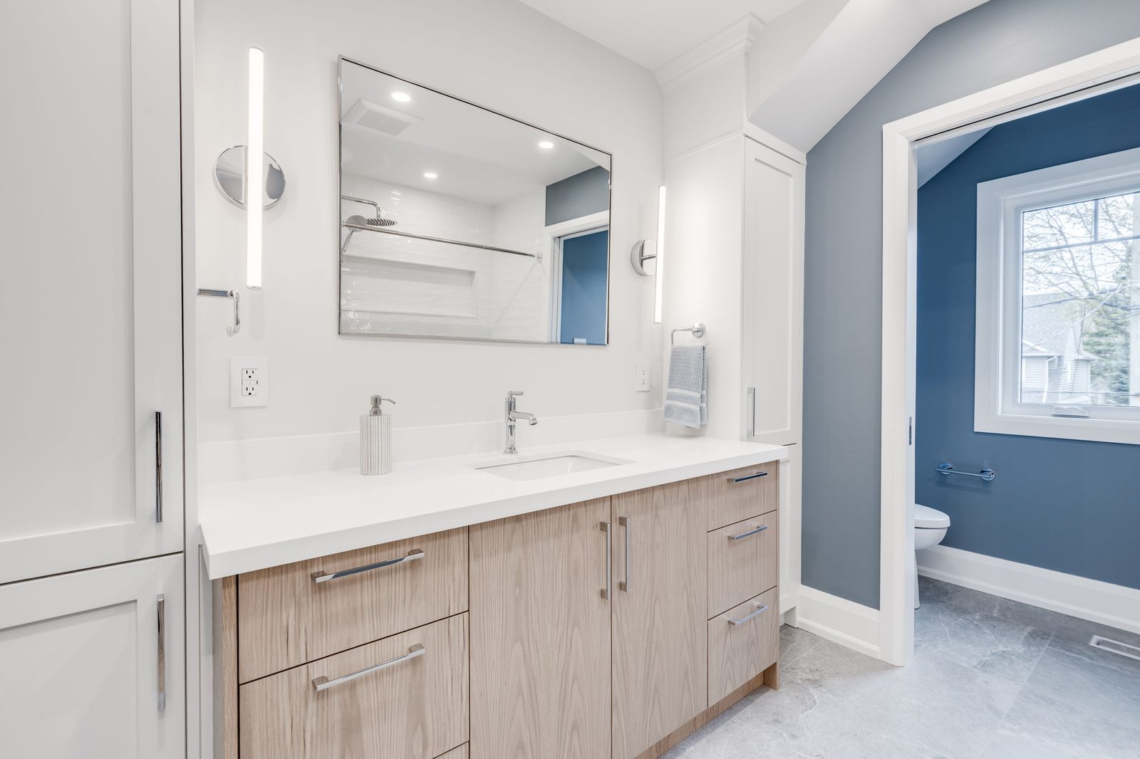 Main bathroom vanity with the arched structural opening through to the blue accent room beyond.