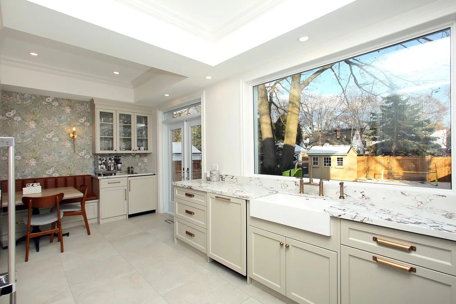 Bright renovated kitchen with warm white cabinetry, quartz counters and a cosy breakfast nook.
