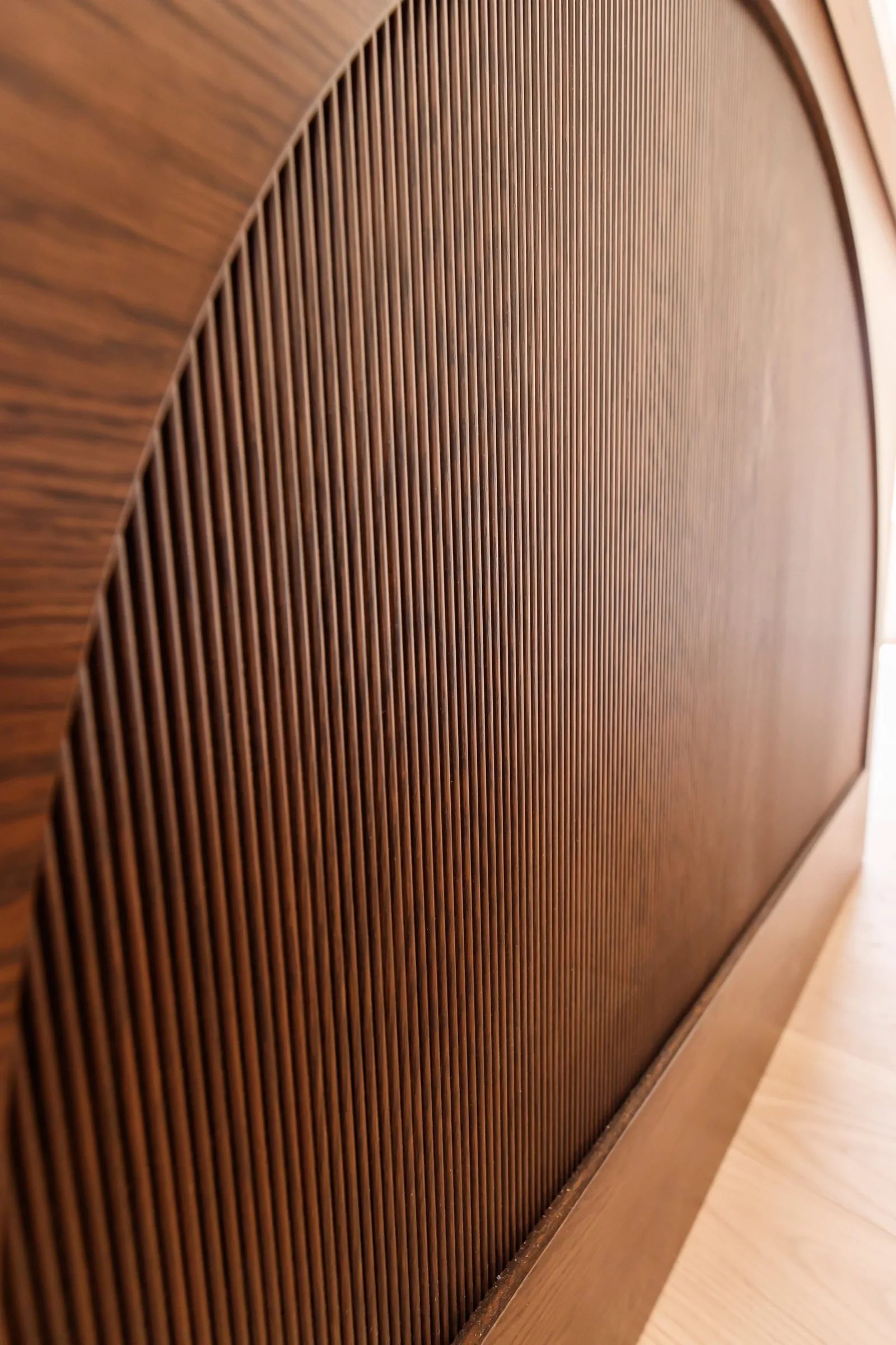 Tight macro of the reeded arch wood panel on the custom kitchen island end.