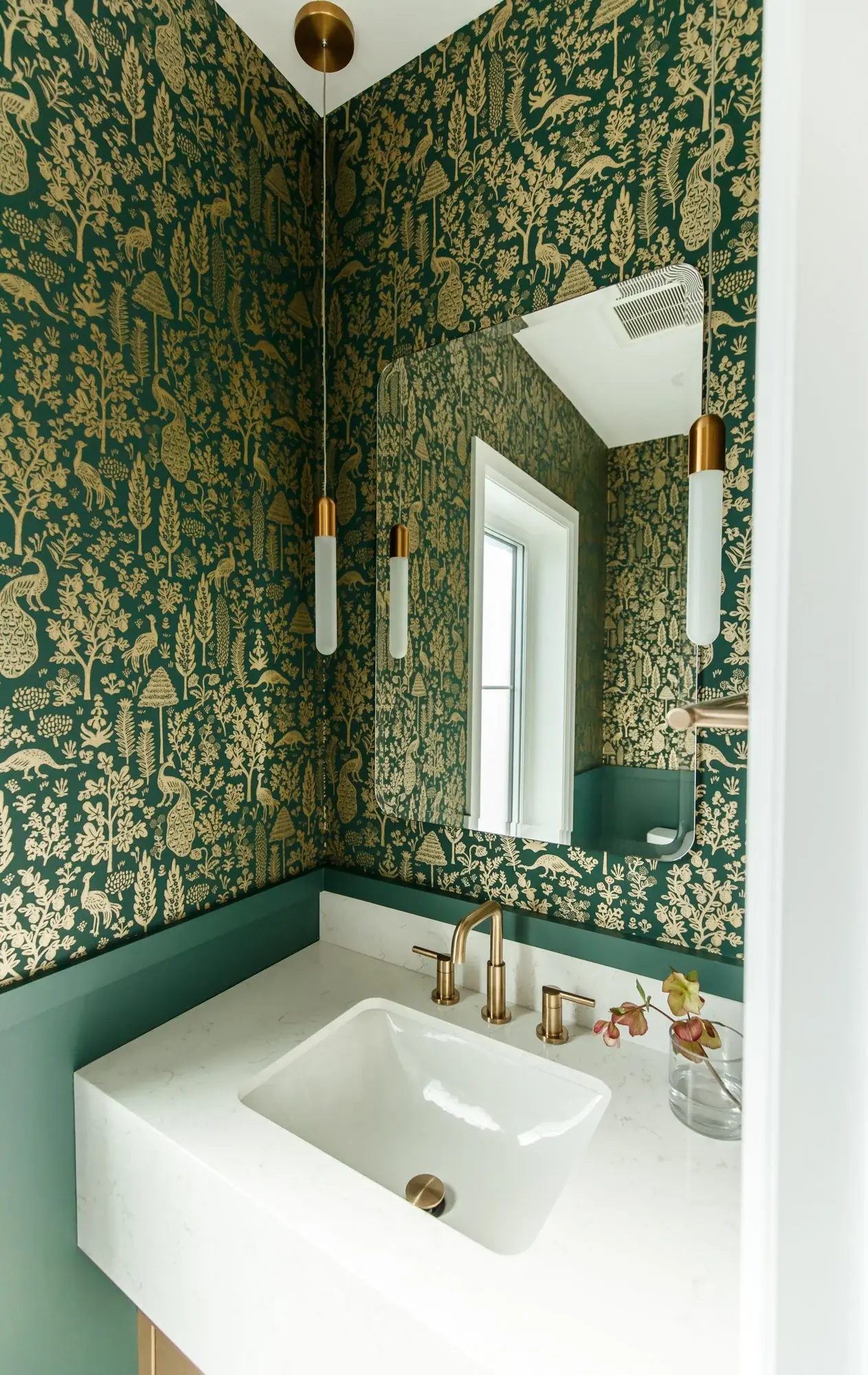 Rich green wallpaper, brass fixtures, and a white floating vanity add colour to a compact Toronto bathroom.