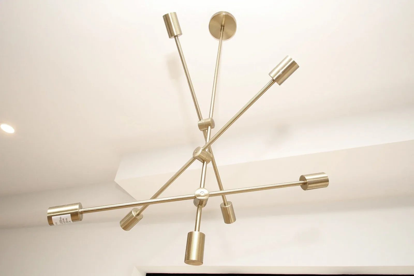 Brushed brass ceiling light adds warm colour against a clean white finished ceiling.