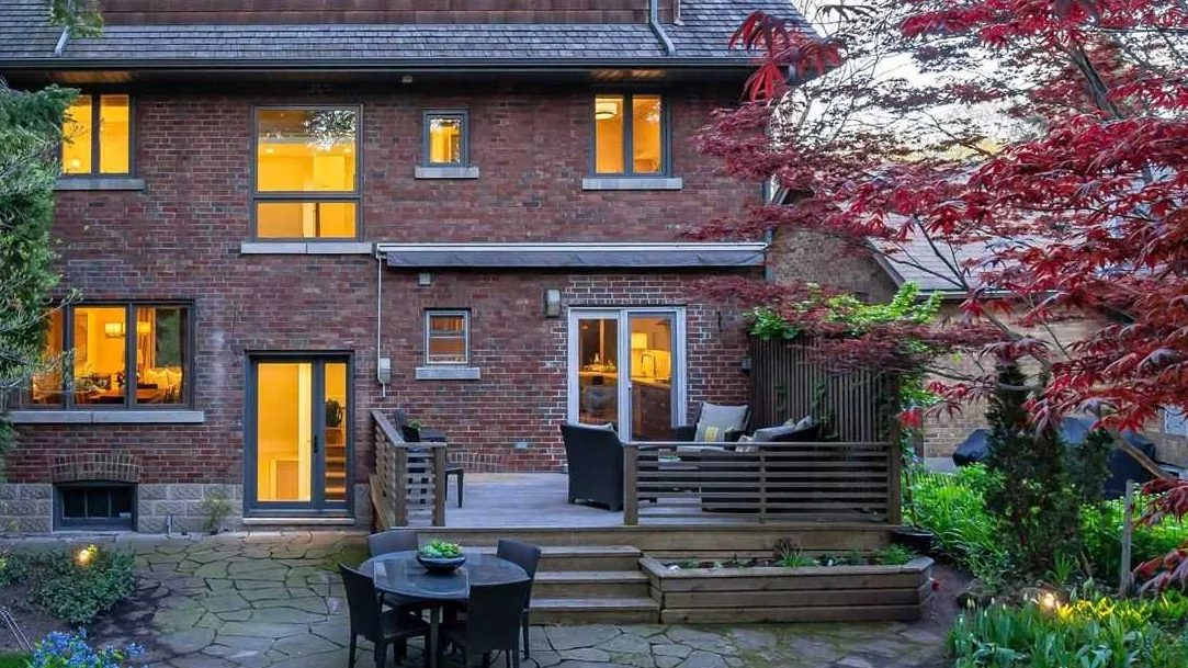 The original brick rear of the house with a wood deck, before the addition, Forest Hideaway project.
