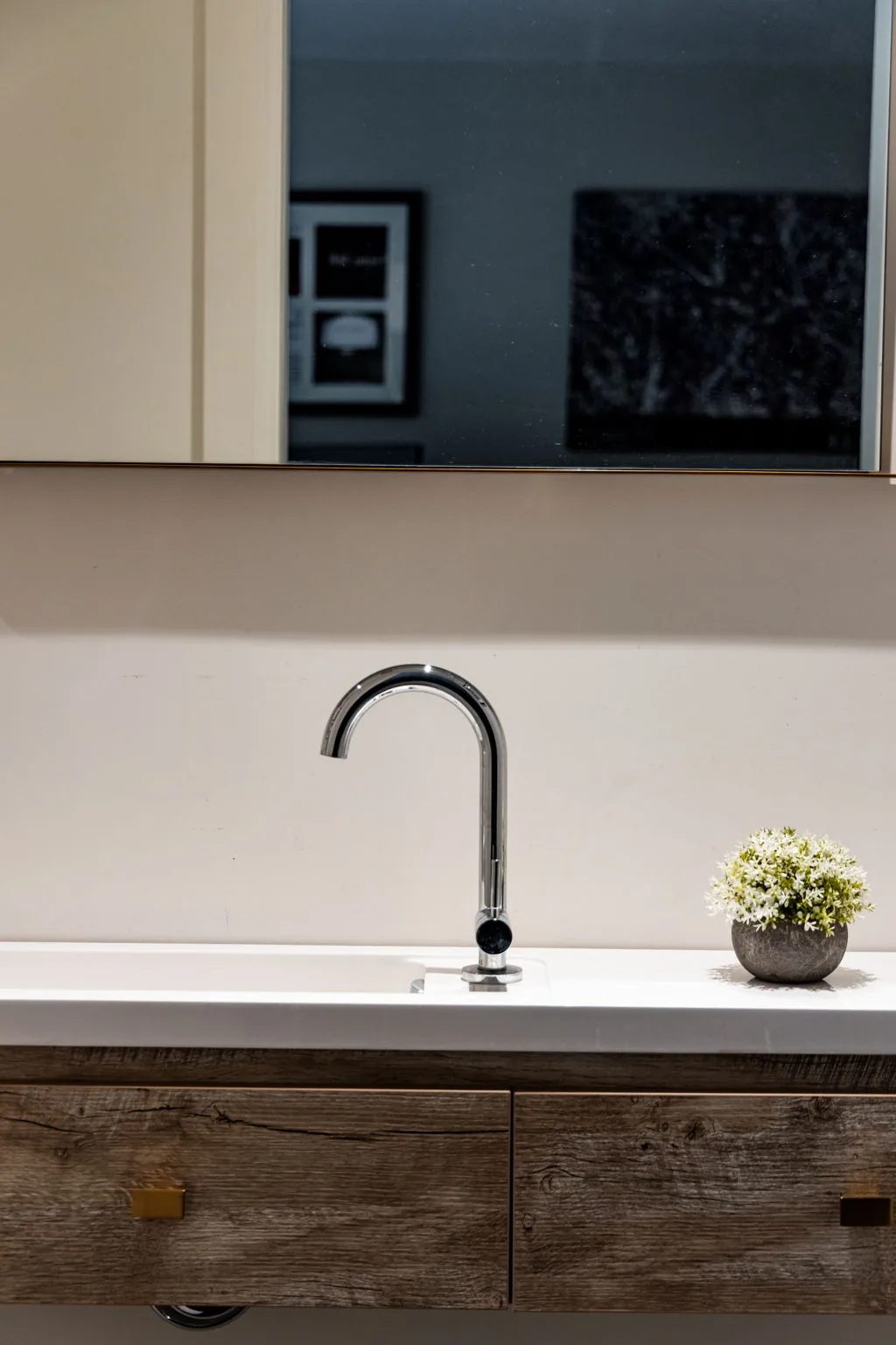 Prep sink with a matte black gooseneck faucet set into a white oak cabinet beneath a marble counter.