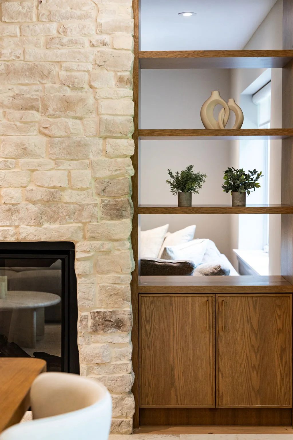 Built-in niche in the natural stone wall styled with a sculpture and potted greenery.