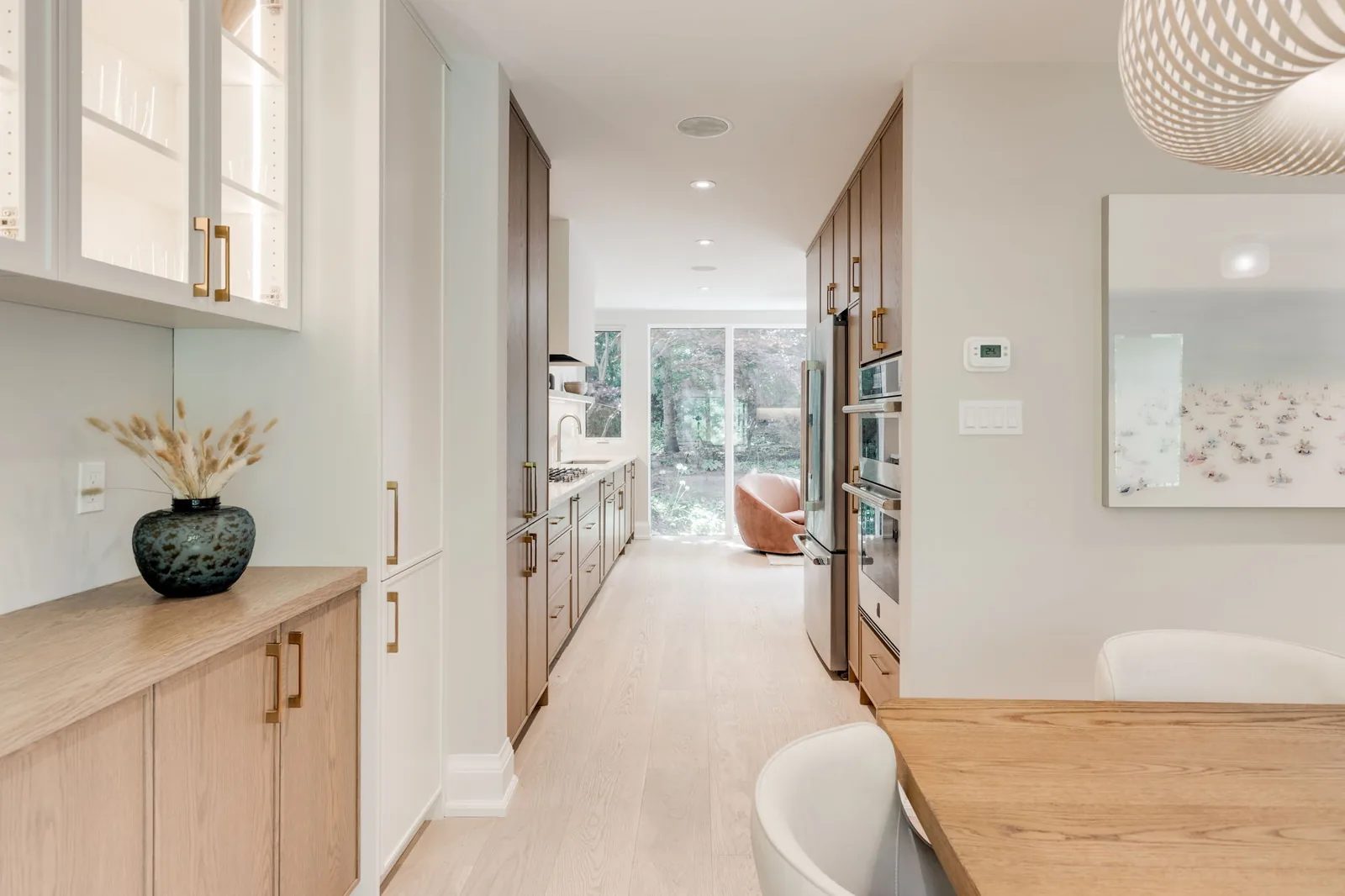 Light oak hallway lined with built-in cabinetry, leading toward the back of the home.
