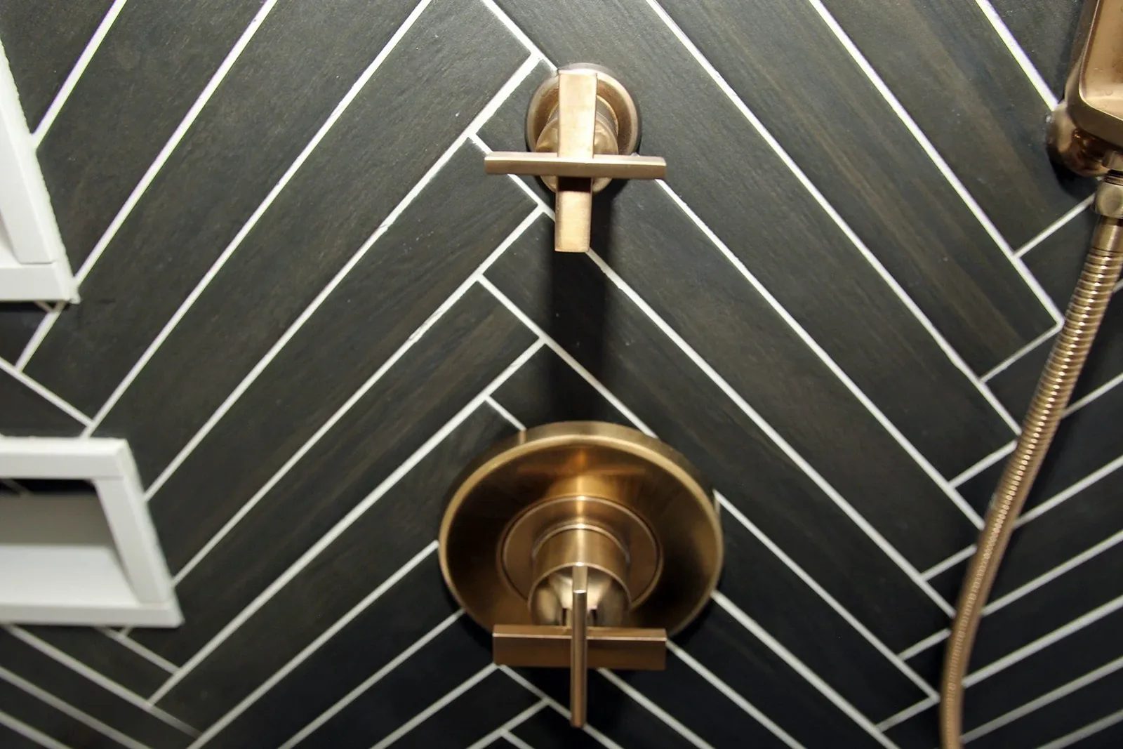 Brass shower controls on dark herringbone tile, Timeless Elegance project