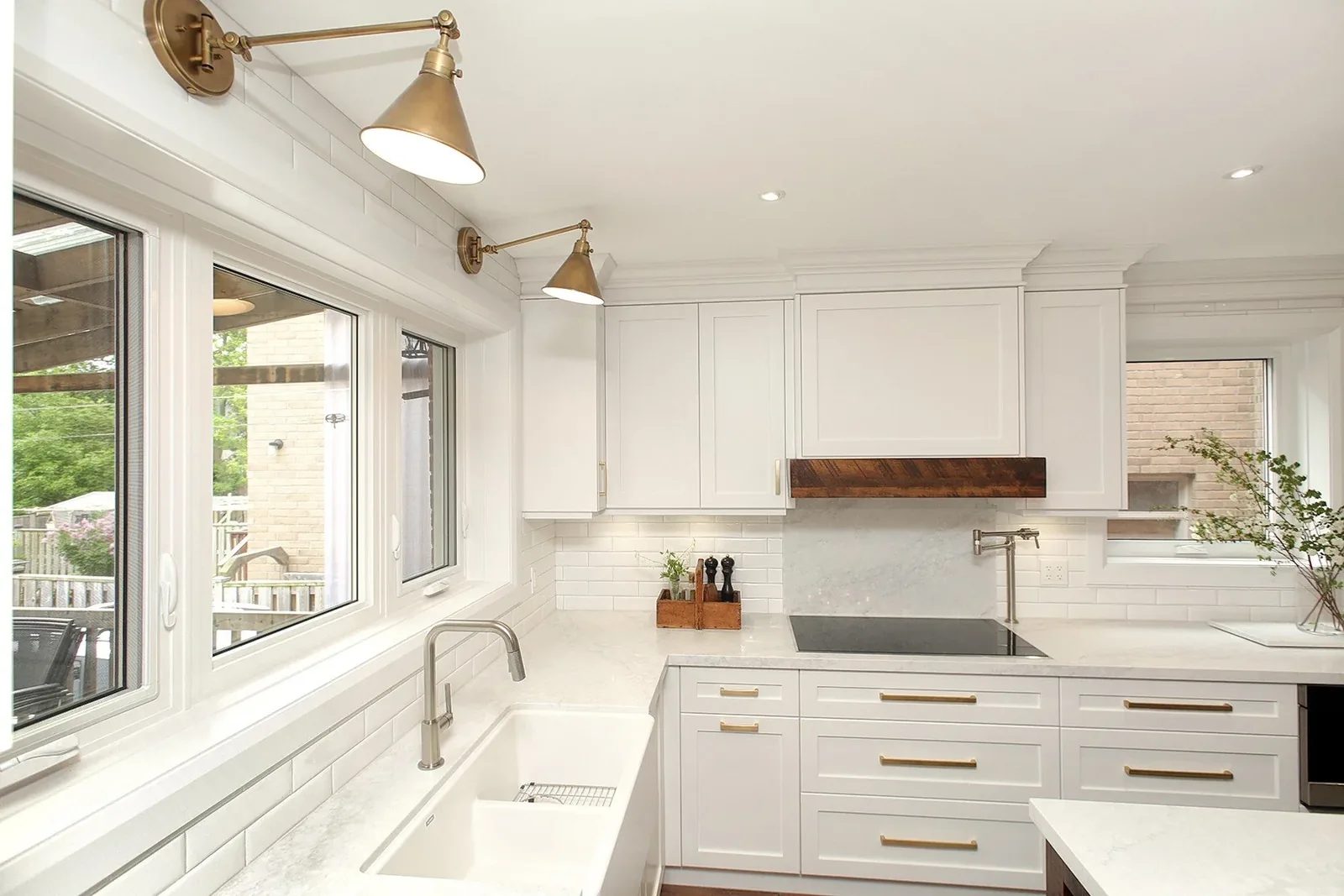 Modern kitchen with white cabinets, brass hardware, and subway tile backsplash.